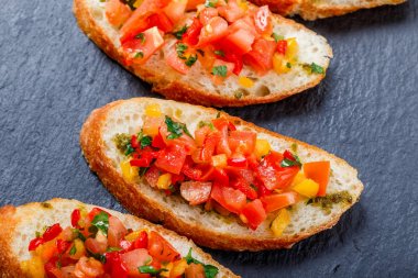 Meze bruschetta ciabatta ekmeği kayrak taş zemin üzerine doğranmış sebze ile kapatın. Lezzetli aperatifler, sandviçler, crostini, kanepe, parti ya da piknik zamanında antipasti. Üstten Görünüm