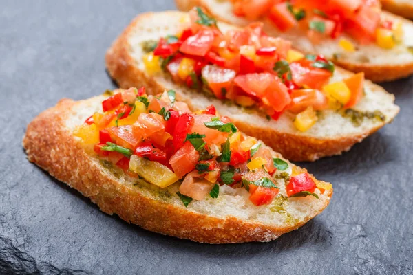 Meze bruschetta ciabatta ekmeği kayrak taş zemin üzerine doğranmış sebze ile kapatın. Lezzetli aperatifler, sandviçler, crostini, kanepe, parti ya da piknik zamanında antipasti. Üstten Görünüm