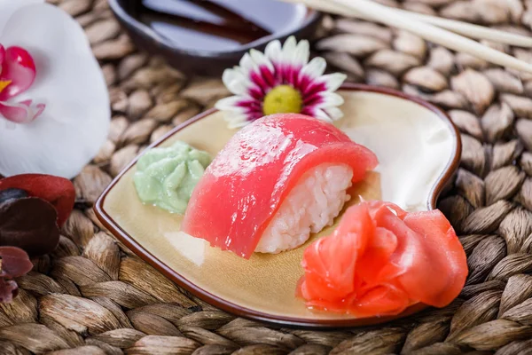Suşi Set nigiri ve suşi rulo bambu zemin üzerine çiçeklerle süslenmiş. Japon mutfağı. Seçici odak