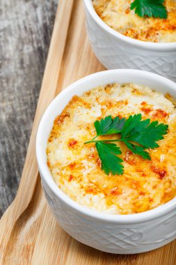 Sulu tavuk, mantar, krema sos ve peynir kesme tahtası ahşap arka plan üzerinde üzerinde sıcak Julienne iki kâse. Etli meze