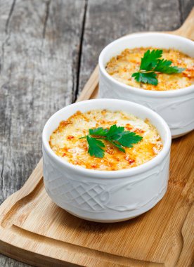 Sulu tavuk, mantar, krema sos ve peynir kesme tahtası ahşap arka plan üzerinde üzerinde sıcak Julienne iki kâse. Etli meze