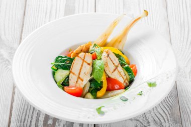 Taze salata tavuk göğsü, Bebek ıspanak, fesleğen, domates, armut, salatalık plaka ahşap zemin üzerine kapatın. Üstten Görünüm