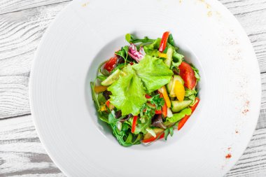 Karnabahar, roka, marul, domates, salatalık, tatlı biber ahşap arka plan üzerinde taze salata. Üstten Görünüm