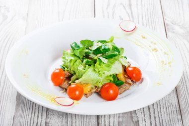 Taze salata tavuk göğsü, Bebek ıspanak, marul, domates ve peynirle ahşap arka plan üzerinde kapat