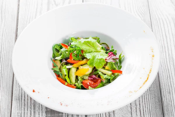 Karnabahar, roka, marul, domates, salatalık, tatlı biber ahşap arka plan üzerinde taze salata. Üstten Görünüm