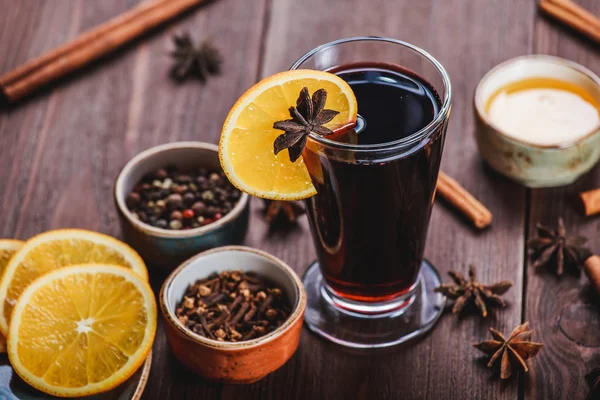 Weihnachtsglühwein mit Zimt, Anissternen, Honig und Orangenscheiben auf hölzernem Hintergrund mit Weihnachtslicht — Stockfoto