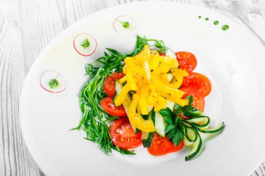 Taze salata domates, salatalık, turp, tatlı biber ve soğan bir plaka üzerinde ahşap arka plan ile kapatın. Üstten Görünüm