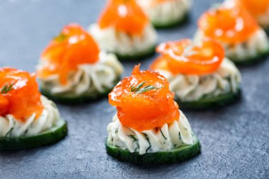 Meze kanepe somon, salatalık ve kayrak taş zemin üzerine krem peynir ile kapatın. Lezzetli aperatifler, sandviçler, crostini, brushetta, parti ya da piknik zamanında antipasti. Üstten Görünüm