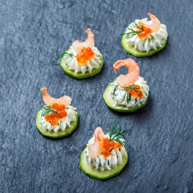 Meze kanepe kırmızı havyar, karides ve kayrak taş zemin üzerine krem peynir ile kapatın. Lezzetli aperatifler, sandviçler, crostini, bruschetta, parti ya da piknik zamanında antipasti. Üstten Görünüm