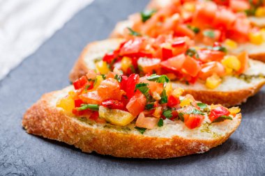Meze bruschetta ciabatta ekmeği kayrak taş zemin üzerine doğranmış sebze ile kapatın. Lezzetli aperatifler, sandviçler, crostini, kanepe, parti ya da piknik zamanında antipasti. Üstten Görünüm