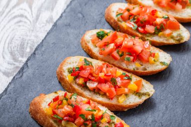 Meze bruschetta ciabatta ekmeği kayrak taş zemin üzerine doğranmış sebze ile kapatın. Lezzetli aperatifler, sandviçler, crostini, kanepe, parti ya da piknik zamanında antipasti. Üstten Görünüm