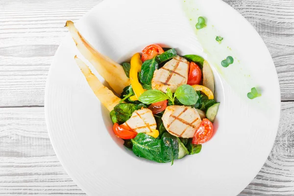 Frischer Salat mit Hühnerbrust, Babyspinat, Basilikum, Kirschtomaten, Birne, Gurke auf Teller auf Holzgrund in Großaufnahme. Ansicht von oben — Stockfoto
