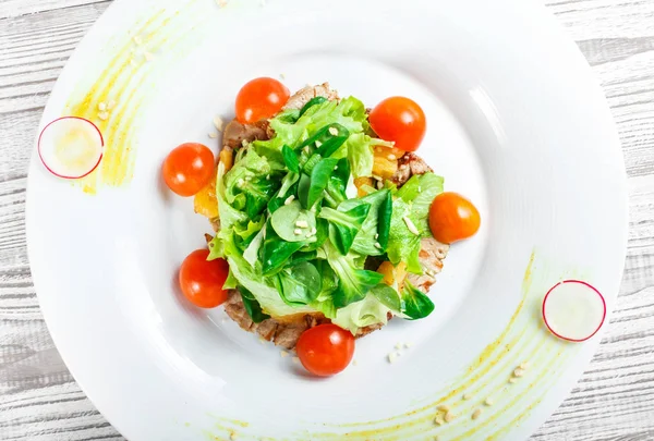 Taze salata tavuk göğsü, Bebek ıspanak, marul, domates ve peynirle ahşap arka plan üzerinde kapat