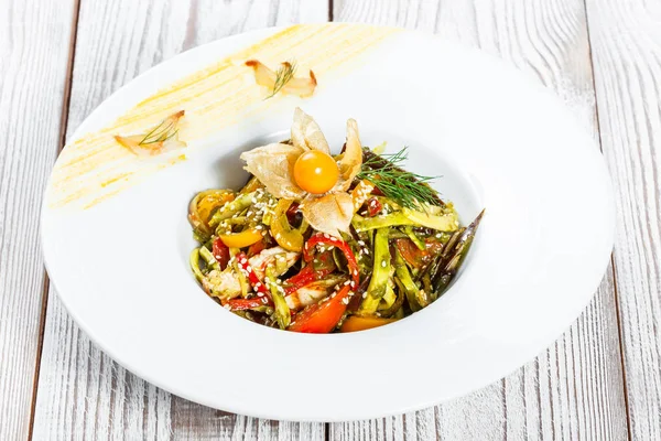 Salada com peito de frango e legumes grelhados, berinjela, pimentão doce, tomates, abacate e physalis no prato no fundo de madeira perto. Vista superior — Fotografia de Stock