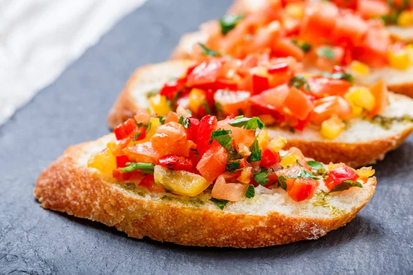 Meze bruschetta ciabatta ekmeği kayrak taş zemin üzerine doğranmış sebze ile kapatın. Lezzetli aperatifler, sandviçler, crostini, kanepe, parti ya da piknik zamanında antipasti. Üstten Görünüm