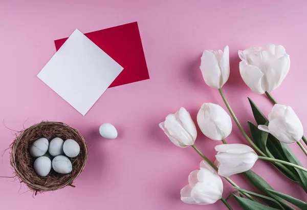 Ovos de Páscoa em ninho e flores de tulipa no fundo da primavera. Vista superior com espaço de cópia. Feliz cartão de Páscoa . — Fotografia de Stock