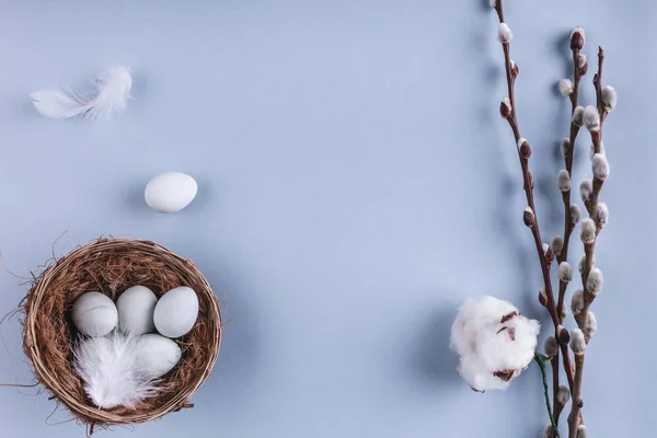 Ovos de Páscoa em ninho e flores de primavera em fundo de férias. Vista superior com espaço de cópia. Feliz cartão de Páscoa . — Fotografia de Stock