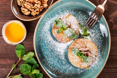 Pişmiş elma tarçın, ceviz ve ahşap arka plan üzerinde tabakta bal ile. Sağlıklı vegan gıda, lezzetli tatlı. Üstten Görünüm