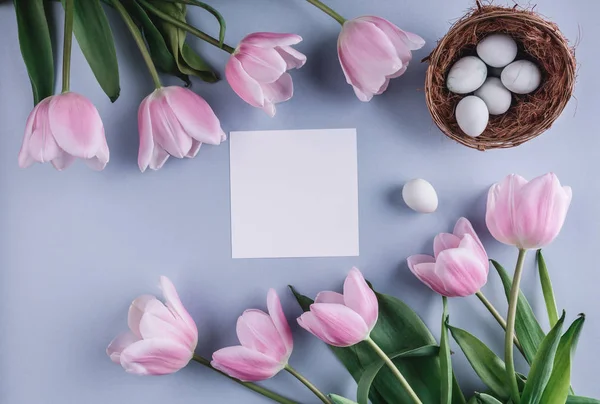 Ovos de Páscoa em ninho e flores de tulipas no fundo de primavera. Vista superior com espaço de cópia. Feliz cartão de Páscoa — Fotografia de Stock