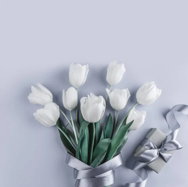 Bos witte tulpen bloemen met cadeau op blauwe achtergrond. Klaar voor de lente. Plat lag, top uitzicht — Stockfoto