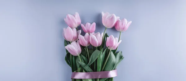 Stelletje roze tulp bloemen op blauwe achtergrond. Klaar voor de lente. Paaskaart gelukkig. Plat lag, top uitzicht — Stockfoto