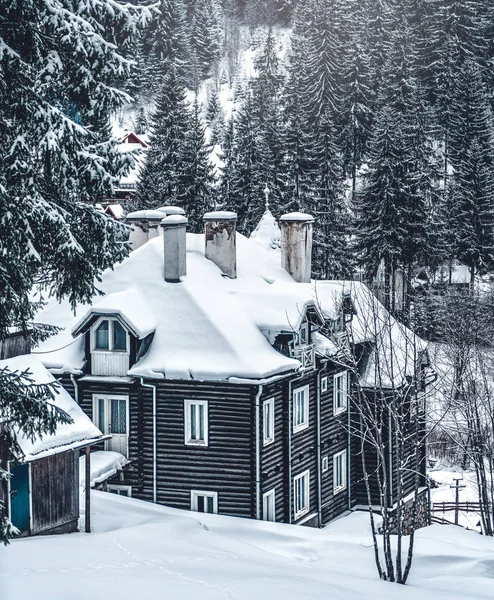 Vinterhus på vinterfjällslandskap med vita snöiga granar. Fantastisk utsikt över snötäckt skogsbevuxen bergssluttning. Julhelgen koncept. Karpaterna, Europa — Stockfoto