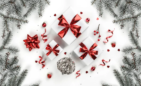 Рождественские елки, подарочные коробки с красной лентой, красные украшения, блеск и конфетти на белом фоне. Рождественские и новогодние открытки, зимние праздники. Плоский, вид сверху — стоковое фото