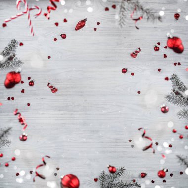 Merry Christmas and New Year background. Xmas holiday card made of flying decorations, fir branches, red balls, snowflakes, sparkles, bokeh, light on wooden background. Selective focus