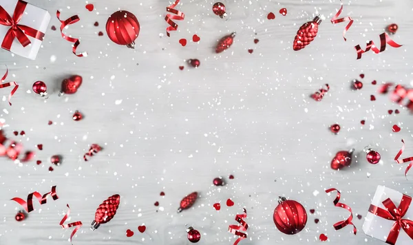 Feliz Natal e Ano Novo fundo. Xmas cartão de férias feito de decorações voadoras, ramos de abeto, bolas vermelhas, flocos de neve, faíscas, bokeh, luz sobre fundo de madeira. Foco seletivo — Fotografia de Stock