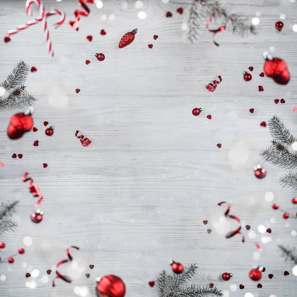 Frohe Weihnachten und Neujahr Hintergrund. Weihnachtskarte aus fliegenden Dekorationen, Tannenzweigen, roten Kugeln, Schneeflocken, Funkeln, Bokeh, Licht auf Holzgrund. Selektiver Fokus — Stockfoto