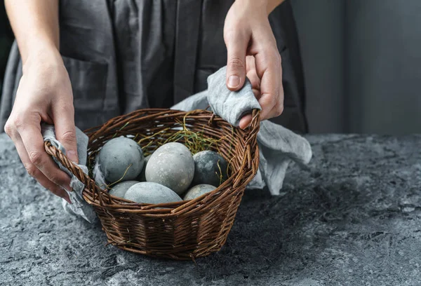 Nő kezét fonott kosár húsvéti tojás sötét háttérrel. Kellemes húsvéti ünnepeket, szelektív fókuszt — Stock Fotó