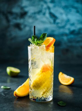 Nane, zencefil, portakal ve koyu mavi arka plan üzerinde cam kavanozda buz ile taze limonata. Yaz soğuk içecek ve kokteyl