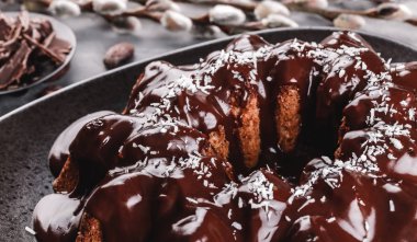 Paskalya kek çikolata, cevizli, bahar çiçekleri, Bıldırcın yumurta karanlık bir taş zemin üzerine. Mutlu Paskalya kutlamaları