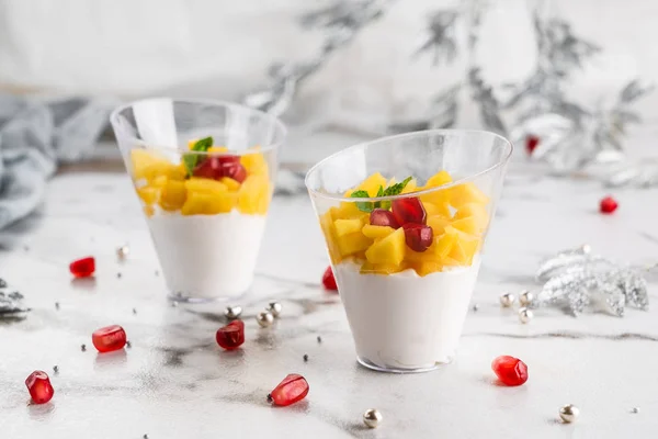 Dessert di mousse saporito con mango e bacche in un bicchiere su sfondo chiaro da vicino. Delizioso dessert e barretta di cioccolato, da vicino — Foto Stock