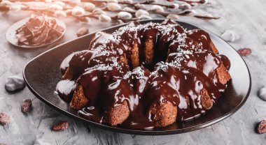 Paskalya kek çikolata, Hindistan cevizi, bir taş zemin üzerine bahar çiçekleri ile. Mutlu Paskalya kutlamaları