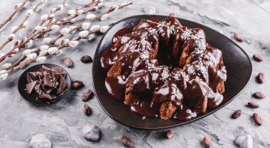 Paskalya kek çikolata, Hindistan cevizi, bir taş zemin üzerine bahar çiçekleri ile. Mutlu Paskalya kutlamaları