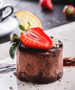 Lezzetli çikolatalı cheesecake veya üzerinde çilek ve nane arkaplanı olan buzlu kek.