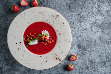 Şeftalili çilekli gazpacho çorbası, kremalı ve açık mavi arka planda naneli. Yaz meyveli tatlı, sağlıklı vejetaryen yemeği, üst manzara.