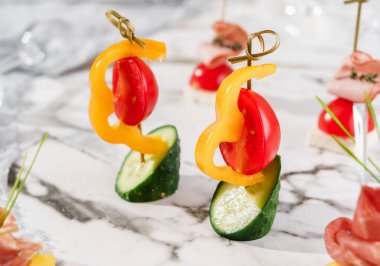 Mermer ziyafet masasında sebzeli lezzetli aperatifler. Yemek servisi, kanepe ve atıştırmalıklar, yakın çekim.