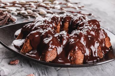 Paskalya kek çikolata, Hindistan cevizi, bir taş zemin üzerine bahar çiçekleri ile. Mutlu Paskalya kutlamaları