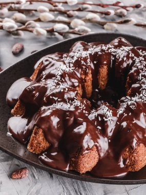 Paskalya kek çikolata, Hindistan cevizi, bir taş zemin üzerine bahar çiçekleri ile. Mutlu Paskalya kutlamaları