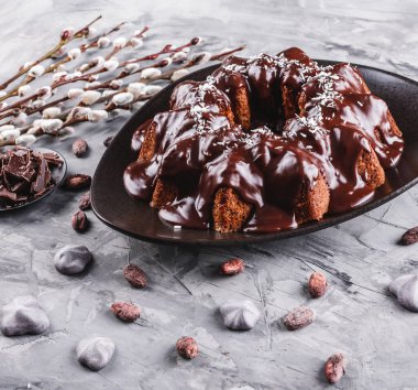 Paskalya kek çikolata, Hindistan cevizi, bir taş zemin üzerine bahar çiçekleri ile. Mutlu Paskalya kutlamaları