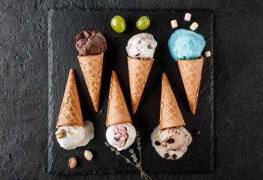 Siyah taş arka planda waffle külahlı renkli dondurma. Yaz ve tatlı tatlı, güzel manzara.