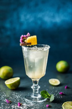 Limonlu taze limonata kokteyli, koyu mavi arka planda nane ve buzlu şarap kadehi. Soğuk yaz içeceği ve kokteyl