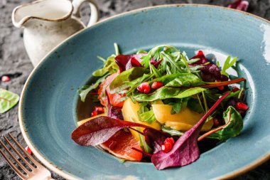 Sebzeli taze meyve salatası ve koyu arkaplanda sos. Sağlıklı yemek, vejetaryen diyeti, yakın çekim.