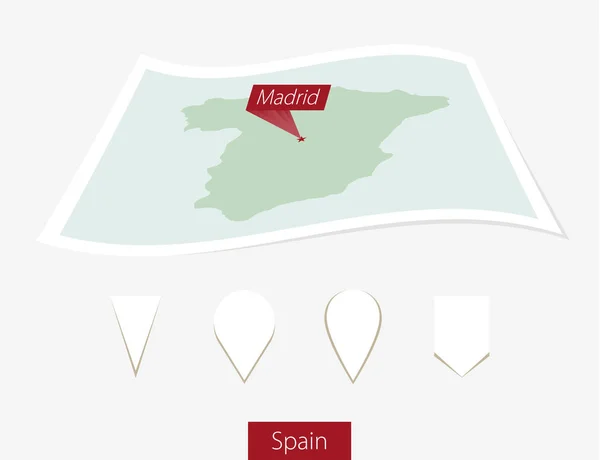 Mapa en papel curvado de España con capital Madrid sobre fondo gris . — Vector de stock