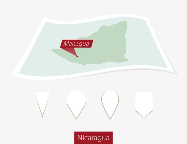 Gebogene Papierkarte von Nicaragua mit Hauptstadt Managua auf grauem Hintergrund. — Stockvektor