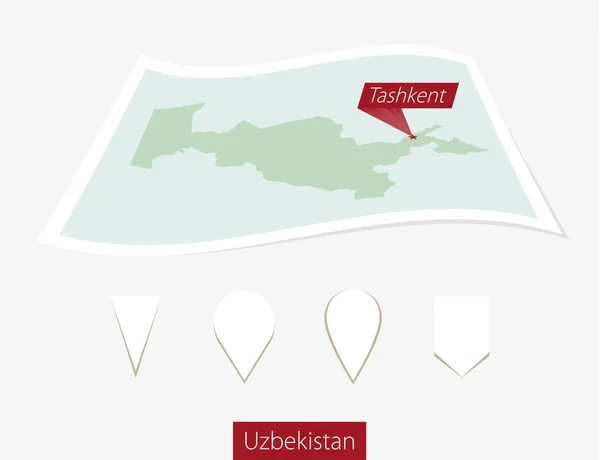 ウズベキスタンの首都タシケント灰色の背景の上に紙の地図に曲がる. — ストックベクタ