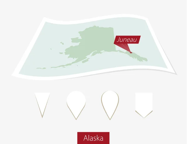 Кривая бумажная карта штата Аляска со столицей Джуно на сером фоне . — стоковый вектор