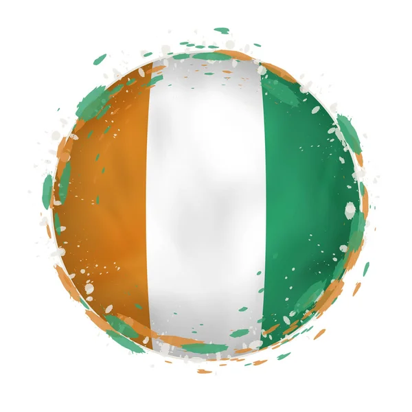 Round grunge flag of Ivory Coast with splashes in flag color. — Stock Vector